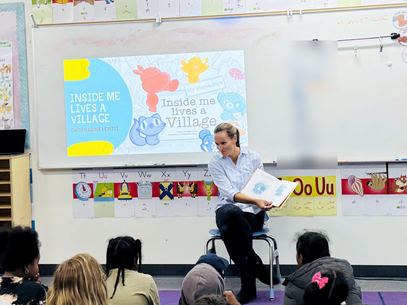 Nadine Levitt reading Inside Me Lives a Village to a class during an author visit