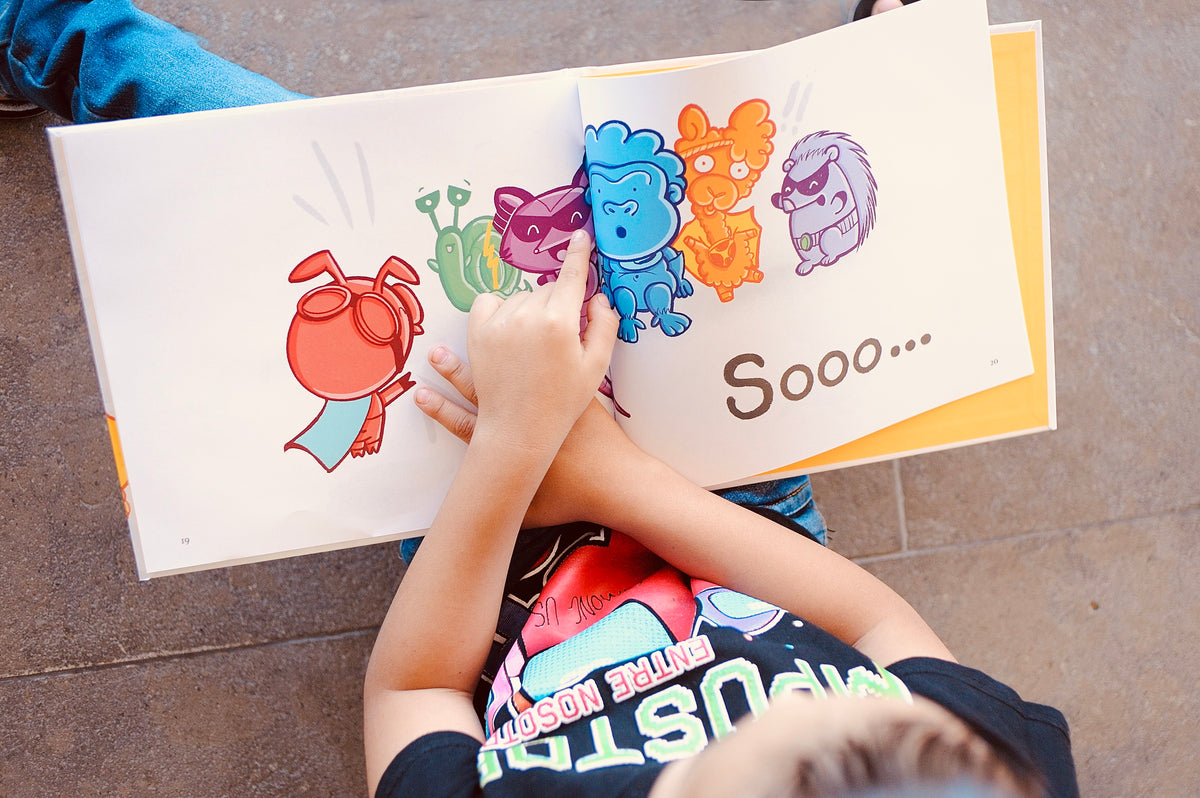 A child reading Inside Me Lives a Superhero, the page with all the superhero characters and the word Sooo