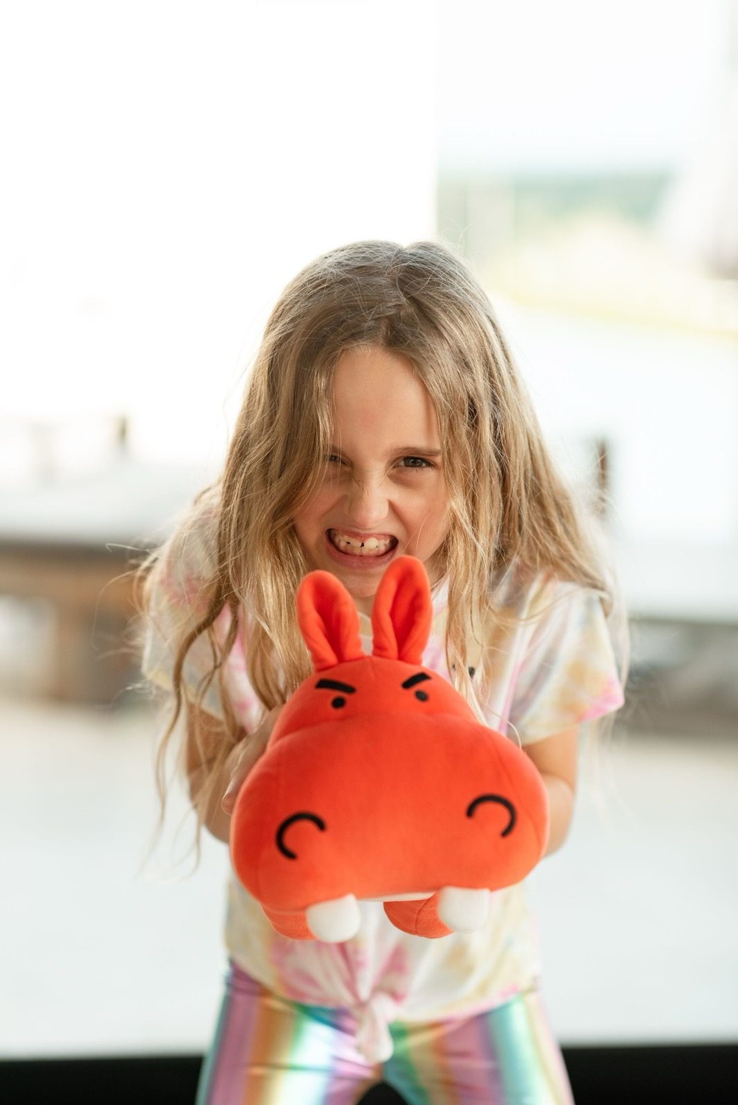 Girl hugging the red angry hippo plush from the My Mama Says anger kit