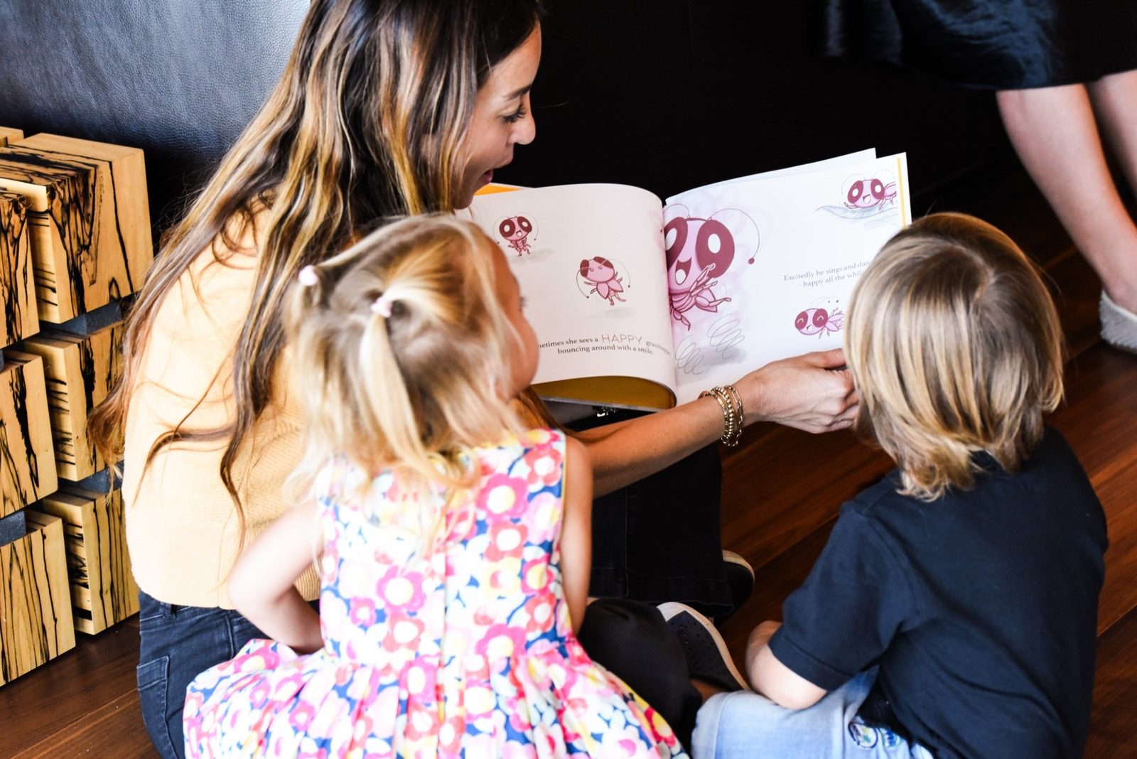 Mom reading a My Mama Says book with her children