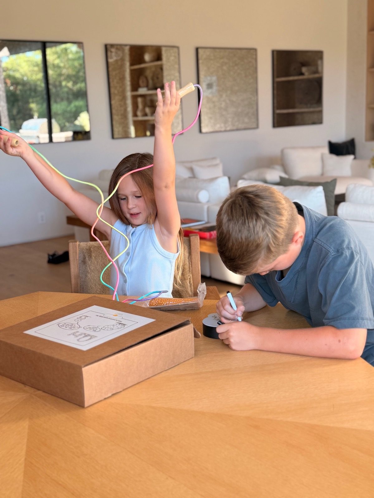 Girl lifting the jump rope from the excitement kit with her brother