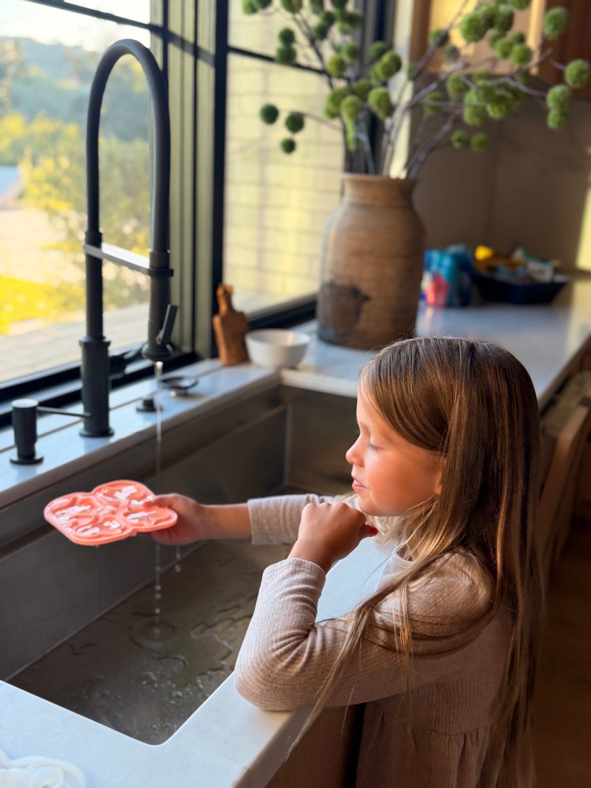 Girl filling the scared penguin ice tray at the sink