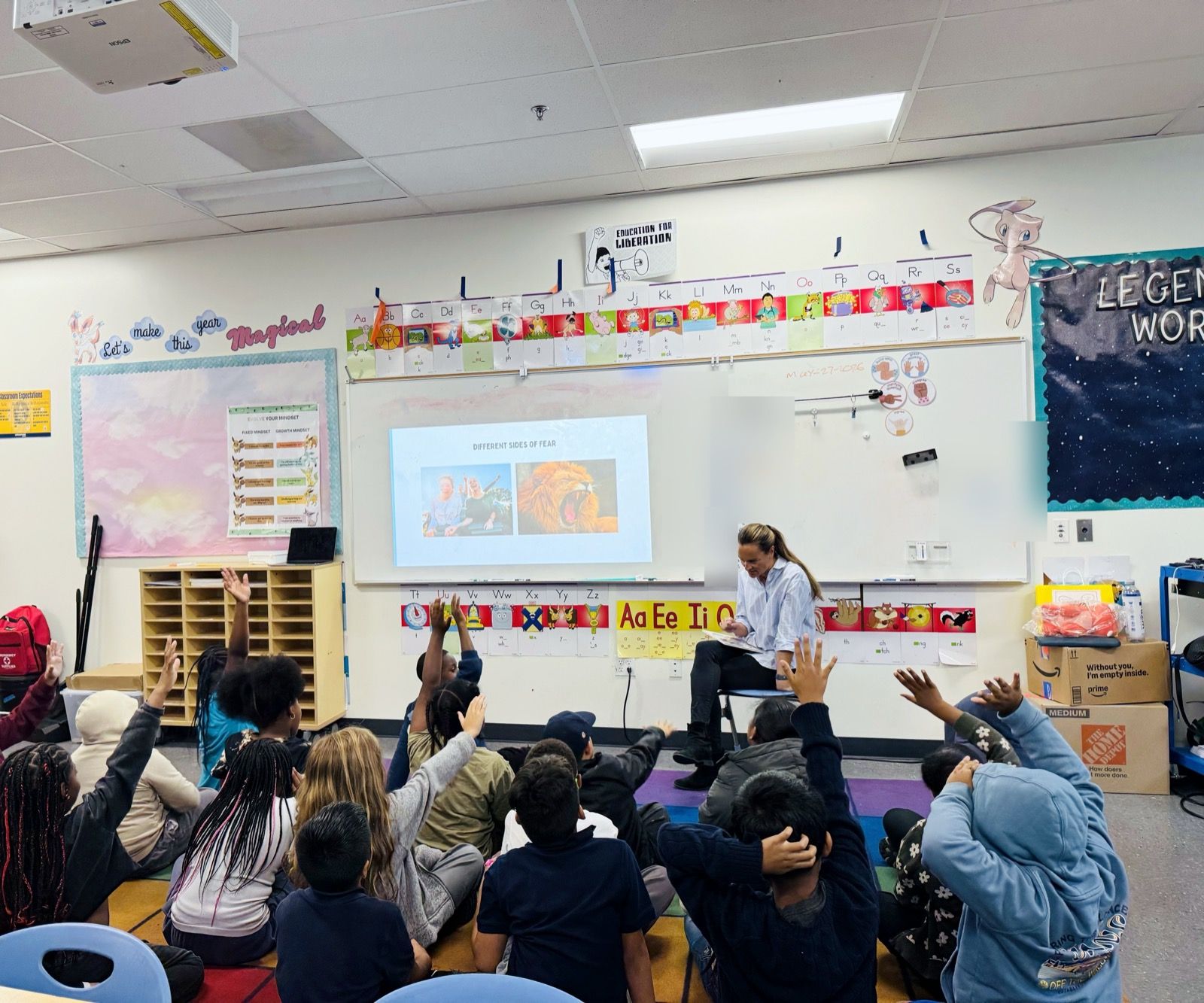 Students with hands raised during an author visit at KIPP Empower